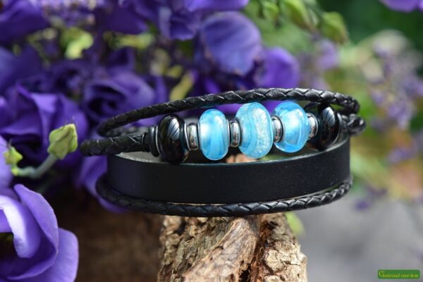Men’s leather memorial bracelet with light blue glass bead containing visible cremation ashes