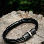 Men’s memorial bracelet with black leather strap and central stainless steel bead containing ashes