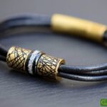 Memorial bracelet with stainless steel bead visibly containing cremation ashes