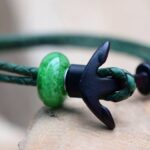 Green leather memorial bracelet with transparent glass bead visibly containing cremation ashes