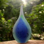 Small green and blue frosted glass urn with sandblasted cat illustration and name incorporated into the tail.