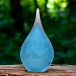 Small frosted blue glass urn with sandblasted cat reaching toward butterflies and a personalized name