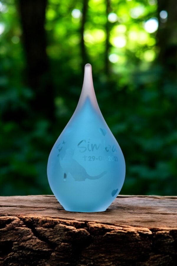 Small frosted blue glass urn with sandblasted cat reaching toward butterflies and a personalized name