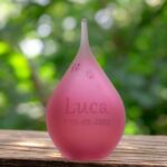 Small frosted pink glass urn with sandblasted dog paw prints
