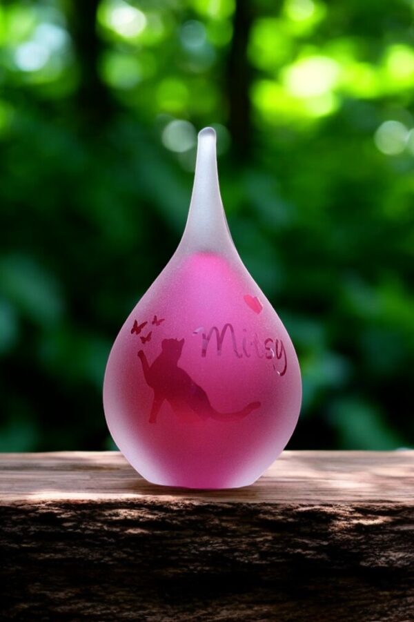 Small frosted pink glass urn with sandblasted cat reaching toward butterflies and a personalized name