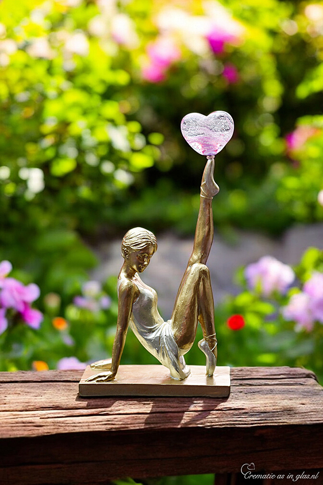 Gold ballerina with white outfit and raised leg