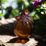 Urn and butterfly of cognac brown transparent glass.