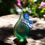 Urn of green and butterfly of blue transparent glass.