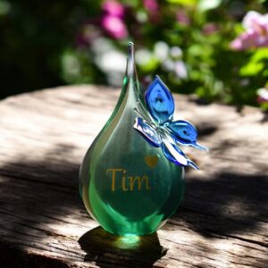 Urn of green and butterfly of blue transparent glass.