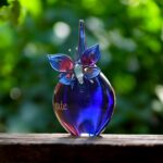 Urn and butterfly of pink and blue transparent glass.