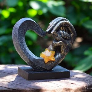 Heart-shaped sculpture with adult hand holding child’s hand