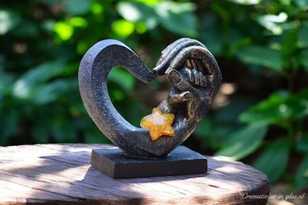 Heart-shaped sculpture with adult hand holding child’s hand