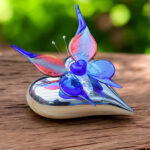 Blue-red glass butterfly on silver-colored ceramic heart