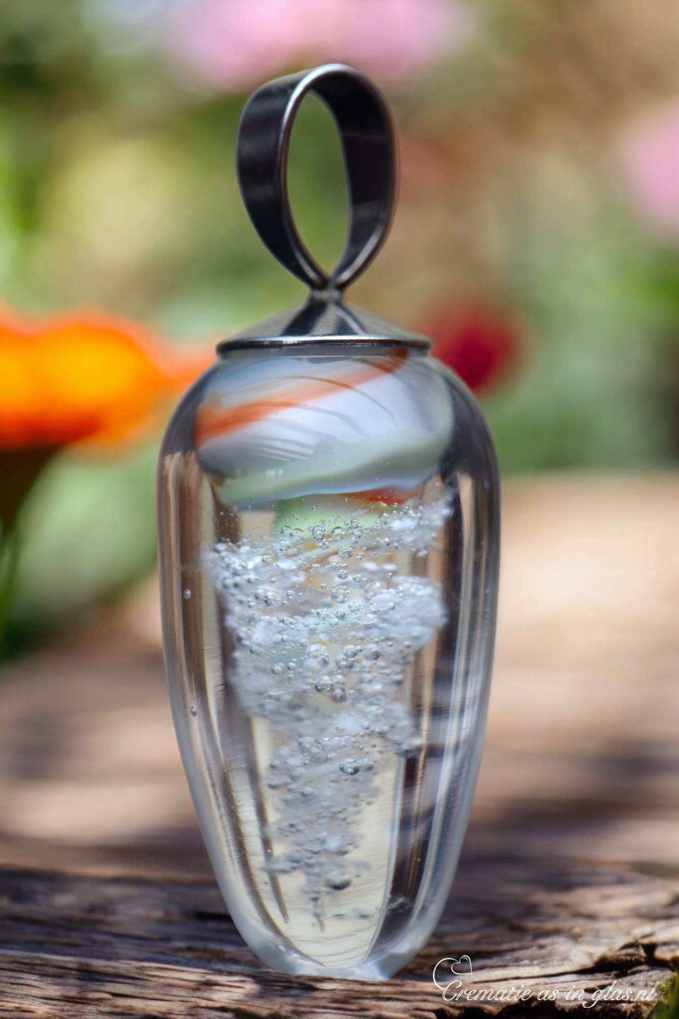 Glass ash pendant with swirling design and embedded cremation ashes.