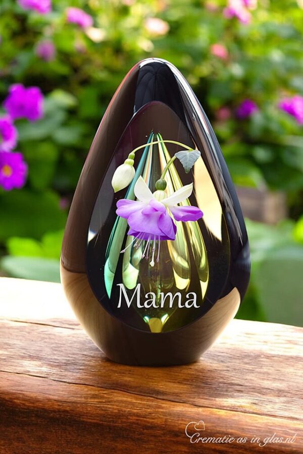 Design urn made of glass with transparent green-yellow ash chamber and image of a fuchsia flower – suitable for cremation ashes.