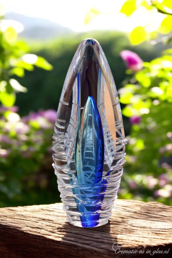 Design urn made of glass with transparent tone-on-tone blue ash chamber and 3D lines of molten glass over the urn – suitable for cremation ashes.