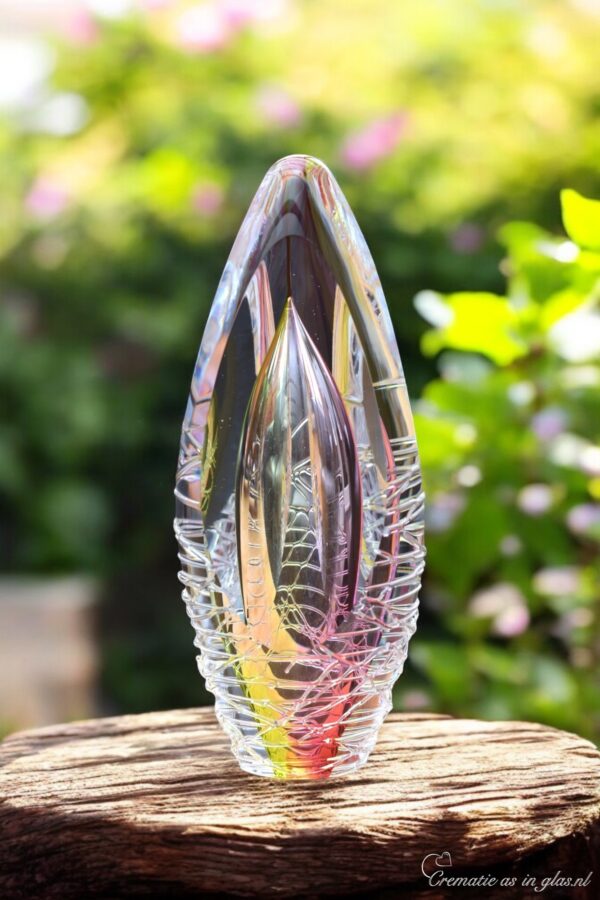 Design urn made of glass with transparent pink-yellow ash chamber and 3D lines of molten glass – suitable for cremation ashes.
