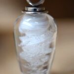 Memorial teardrop pendant with spiral ashes in clear and opaque white glass with stainless steel bail.