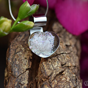 Glass heart pendant with visible ashes in transparent multicolor shimmering glass and 925 sterling silver bail.