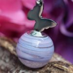 Memorial pendant with visible ashes in lilac glass and stainless steel butterfly charm