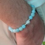 Men’s memorial bracelet with blue chalcedony beads and subtly visible ashes in a light blue glass bead.