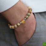 Men’s memorial bracelet with desert jasper beads and non-visible ashes in a matte yellow glass bead.