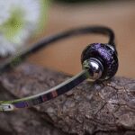 Memorial bangle with invisible ashes in black glass with purple shimmer