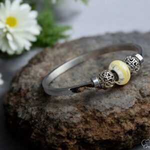 Elegant memorial bangle with semi-visible ashes in gold shimmer glass