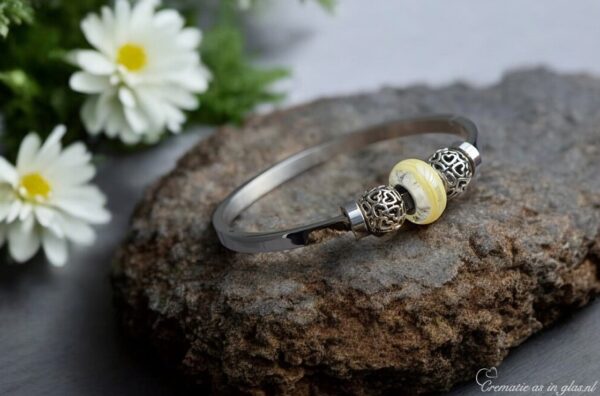 Elegant memorial bangle with semi-visible ashes in gold shimmer glass