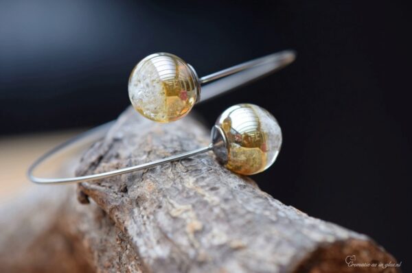 Minimalist memorial bangle with two semi-visible ashes beads in gold shimmer glass and surgical-grade stainless steel.