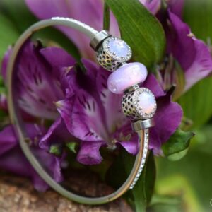 Delicate memorial bangle with invisible ashes in opal pink glass