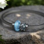 Memorial bangle with visible ashes in transparent blue glass