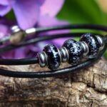 Leather memorial bracelet with invisible ashes in black shimmer glass bead and matching decorative beads