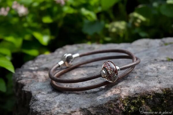 Memorial bracelet with cremation ashes fused in dark brown glass on custom brown leather with stainless steel clasp.