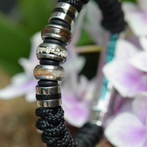 Men’s memorial bracelet with black knotted sailrope and three silver-tone beads containing visible hair and ashes.