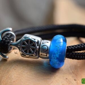 Men’s memorial bracelet with black sailrope band and blue glass bead containing visible cremation ashes