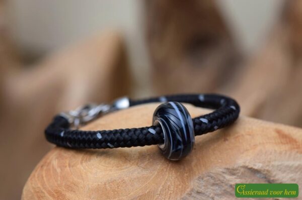 Men’s memorial bracelet with black sailrope band and black-and-white glass bead infused with cremation ashes.
