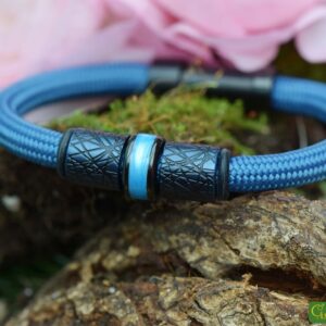Bracelet with dark blue stainless steel design beads and cremation ash bead on a black Sailrope band.