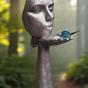 Silver-colored sculpture with face and hand