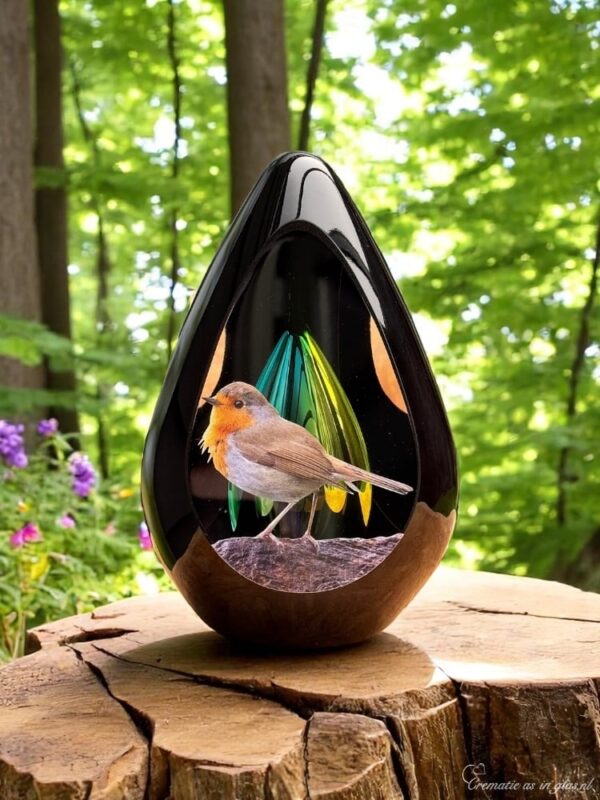Design urn made of glass with transparent green-yellow ash chamber and image of a robin – suitable for cremation ashes.