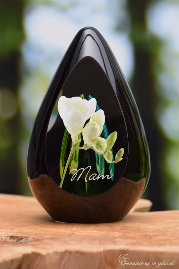Design urn made of glass with transparent green-yellow ash chamber and image of white freesias – suitable for cremation ashes.