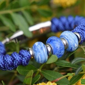 Men’s bracelet with blue knotted sail rope band and three handmade glass beads in marbled blue-white tones