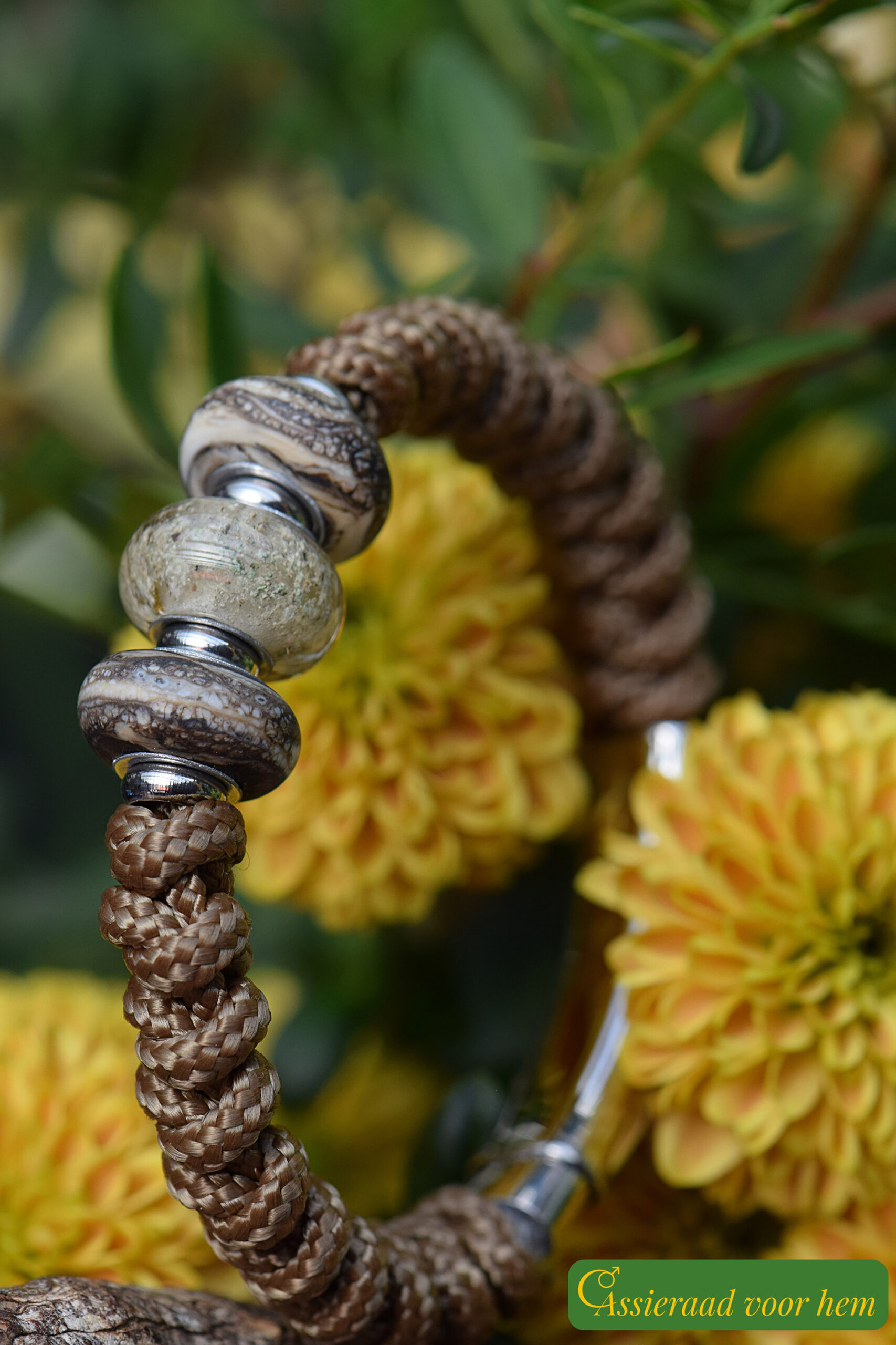 Men’s memorial bracelet in brown Sailrope with visible ashes in a brown glass bead between two mottled sandblasted beads.