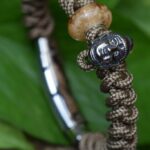 Vertical men’s paracord bracelet with cremation-ash glass bead and stainless-steel Buddha bead.