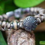 Men’s mottled Sailrope memorial bracelet with beige stainless steel ashes bead beside a stainless steel heart button bead.