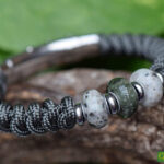 Grey Sailrope memorial bracelet with transparent grey cremation ashes glass bead between two beads.
