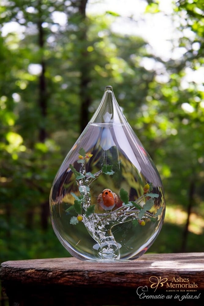 Glass urn with robin bird on oak tree with leaves and acorns