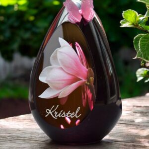 Glass design urn with pink ash chamber and image of a pink magnolia with space for a short name – suitable for cremation ashes.