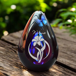 glass design urn with transparent blue ash chamber and silhouette image of a flower – suitable for cremation ashes.