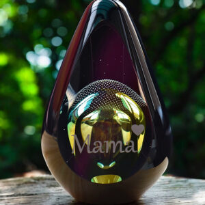 Designer urn made of glass with transparent green-yellow ash chamber and air bubbles above with space for a short name - suitable for cremation ashes.